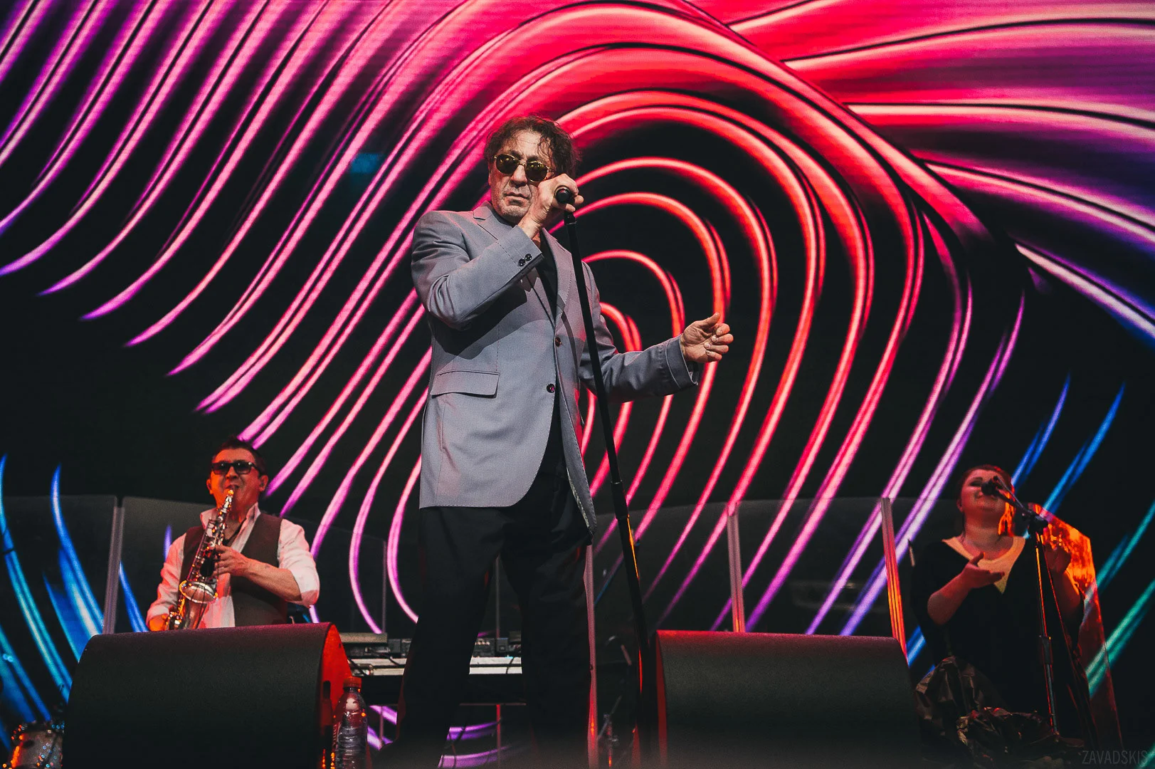 Man in Dark Suit Standing at Microphone – Professional Event Reportage